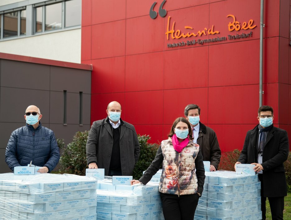 Stellvertretend für alle weiterführenden Schulen nahm Ralph Last, Schulleiter des Heinrich-Böll- Gymnasiums (rechts) die Spende entgegen. Überreicht wurden die Masken von Bernd Schlarp, Geschäftsführer von LEMO, Markus Wilden, Geschäftsführer der Rhein Sieg Werkstätten und Ulrich Reifenhäuser, CSO der Reifenhäuser Gruppe (v.l.n.r.). Die Verteilung an die Schulen koordiniert Tanja Gaspers, Schuldezernentin der Stadt Troisdorf.